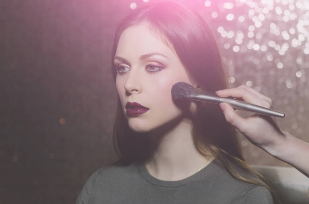 Pretty girl getting powder on face skin with makeup brush - Fotografie, Obrázek