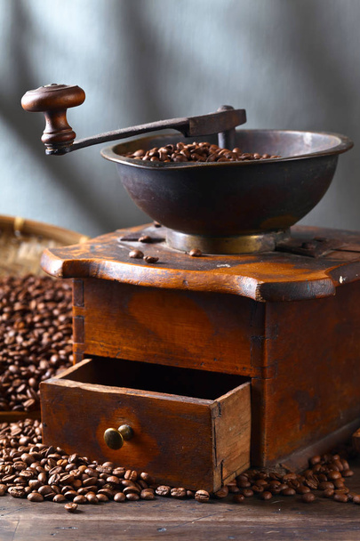 Moedor de café velho e grãos de café torrados na mesa de madeira
  - Foto, Imagem