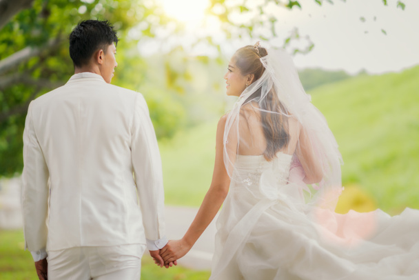 asiatische Dame in Hochzeitskleid laufen mit ihrem Mann, vor der Tür - Foto, Bild