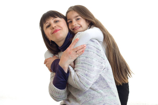 Mother with little daughter hugs in studio - Zdjęcie, obraz