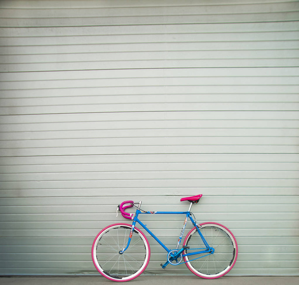 bicycle  against gray metal wall  - Fotó, kép