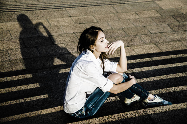  Slim teenage girl  sitting  on the stairs - Zdjęcie, obraz