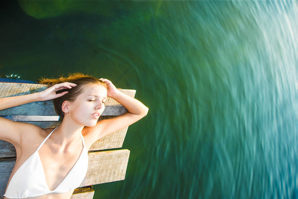 girl lying on wooden pier  - Fotoğraf, Görsel