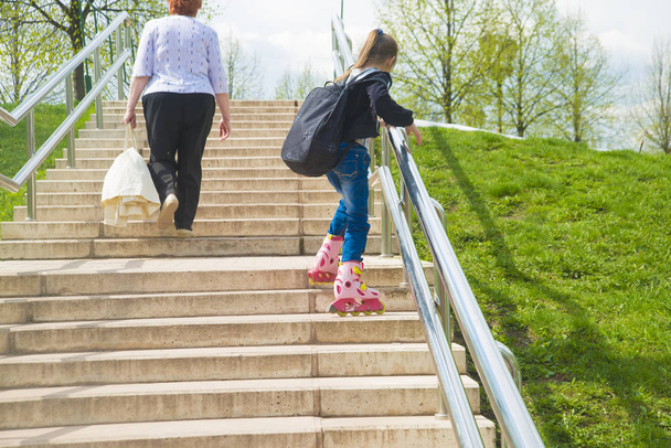 little girl   climbing  up the stairs in roller skates - Φωτογραφία, εικόνα