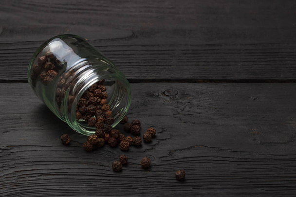 Black pepper grinder and spice on black table. - Foto, immagini