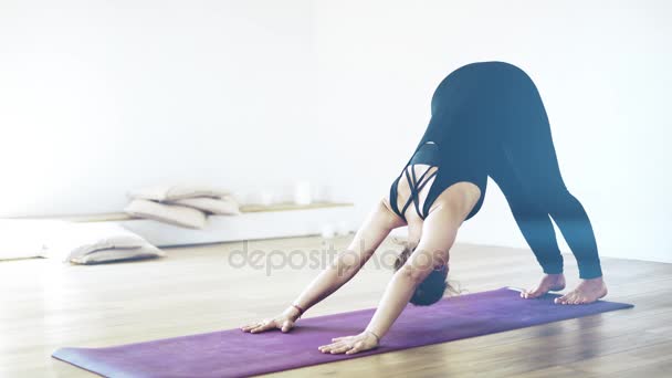 Portrait of a pretty woman in black doing yoga indoors, close up - Video, Çekim