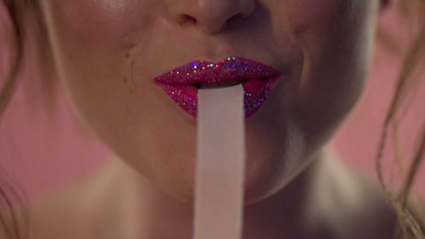 Een vrouwelijke mond eet een lange kauwgom. - Video