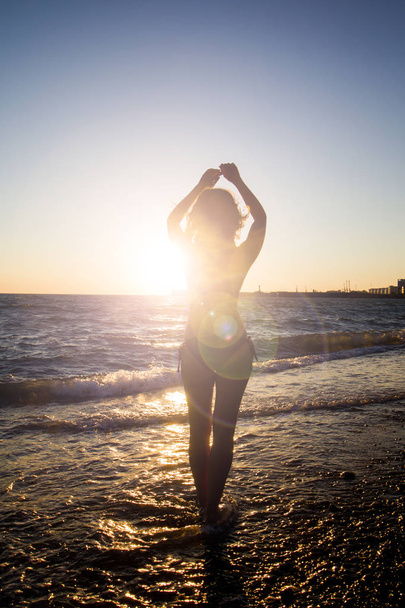 Girl on the beach at sunset - Фото, зображення