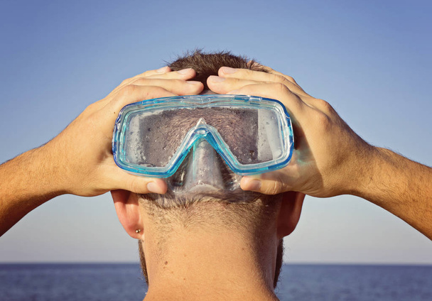 Een man in een duikbril staat achter - Foto, afbeelding