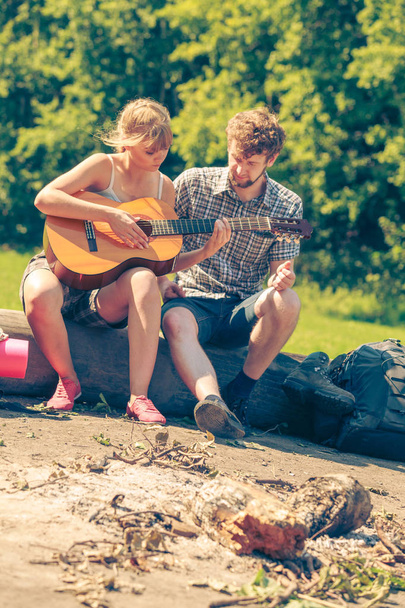Young couple camping playing guitar outdoor - Fotografie, Obrázek
