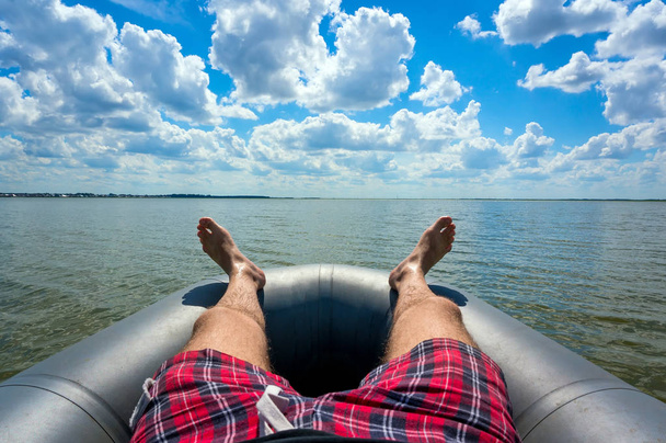 若い男にある灰色の膨脹可能なボートに乗って休憩 - 写真・画像