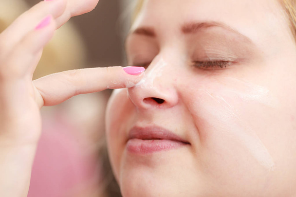 Woman applying face cream with her finger - Foto, Imagem