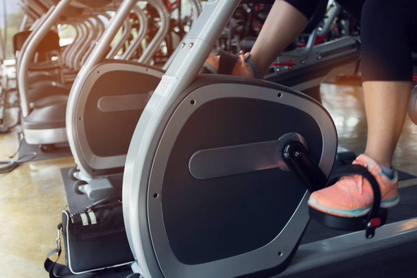 mujer ciclismo quemar grasa en bicicleta máquina cardiovascular en gimnasio
  - Foto, imagen