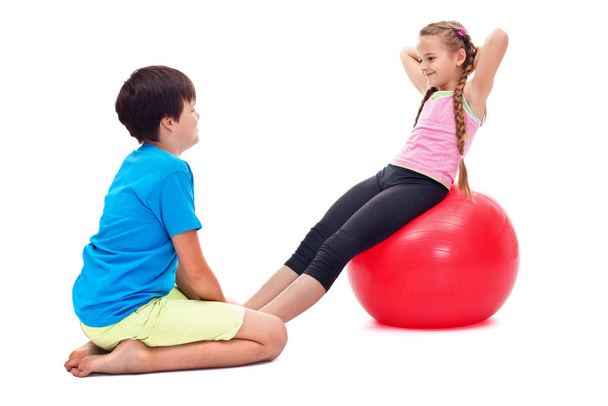 Kids exercising together - using a large rubber gymnastic ball - 写真・画像