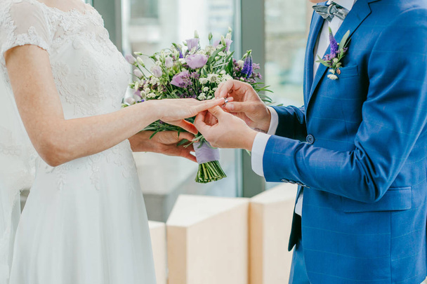 The bride and groom exchange rings. The bride puts the ring on the groom. The groom puts the ring on the bride. - Fotoğraf, Görsel
