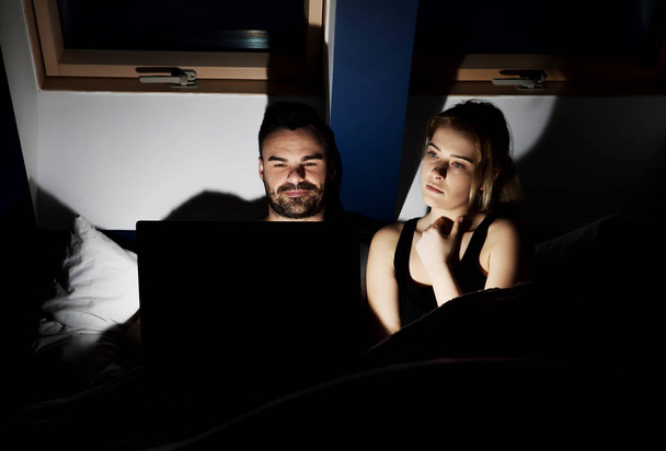 a fiatal pár néz film az ágyban laptop - Fotó, kép