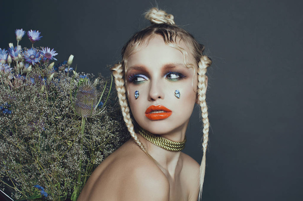 Portrait féminin à la mode en studio avec cheveux, maquillage et fleurs
 - Photo, image