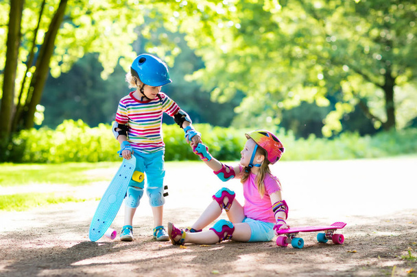 Kinderen rijden skateboard in zomer park - Foto, afbeelding