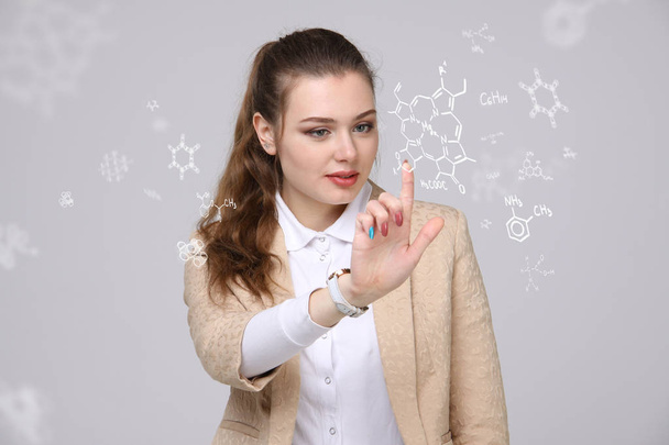 Woman chemist working with chemical formulas on grey background. - Photo, Image