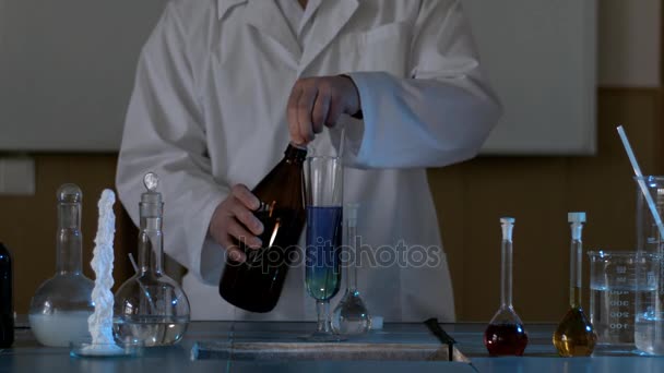 Vedenpuhdistustesti. Pudota sininen neste koeputkeen puhtaalla vedellä. Kemiallisia kokeita tekevä tiedemies
 - Materiaali, video
