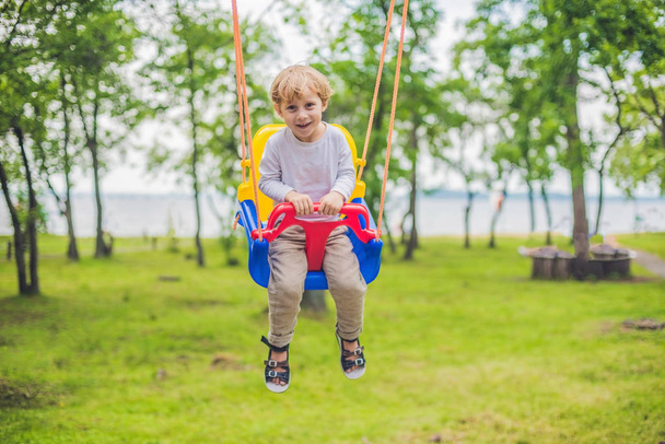 little boy riding on a swing - Foto, Imagen