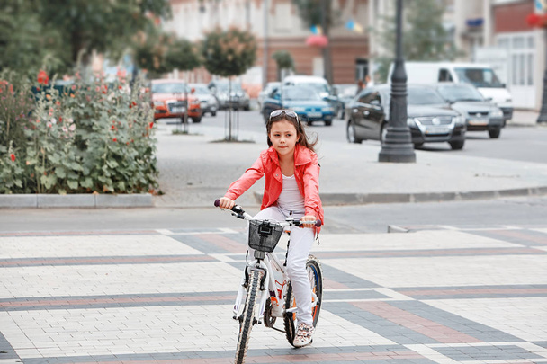 Cute kid girl in blue helmet going to ride her bike - Photo, Image