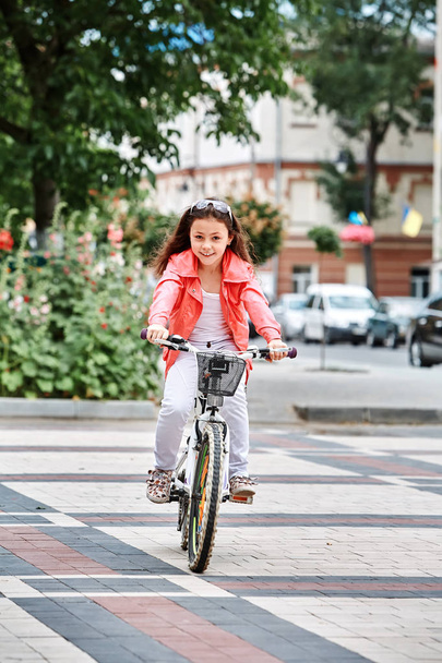 Cute kid girl in blue helmet going to ride her bike - Foto, Imagen
