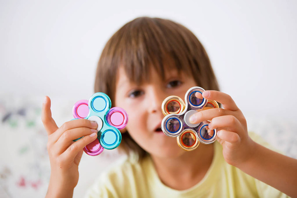 Young boy play with fidget spinner stress relieving toy - Foto, Imagem