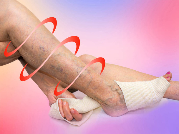 La femme âgée corrigeant un bandage élastique qui lui attachait la jambe
. - Photo, image