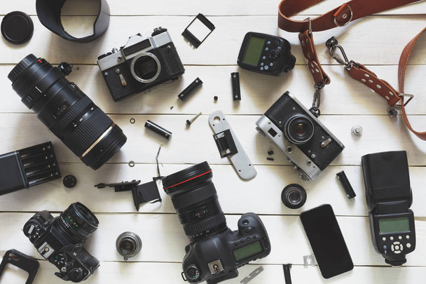 Photographer Workplace, Camera, Lenses And Accessories On White Wooden Background. Top View - Φωτογραφία, εικόνα