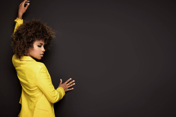 Girl with afro hairstyle posing in yellow jacket. - Fotoğraf, Görsel