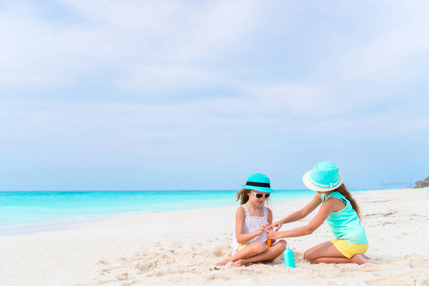 Dvě milující dívky se postarat o sebe na bílé pláži. Koncepce ochrany před ultrafialovým zářením - Fotografie, Obrázek