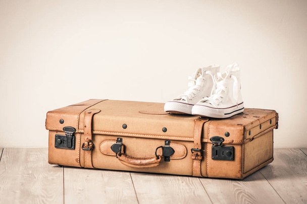sapatilhas e uma mala marrom velha com um efeito retro
 - Foto, Imagem