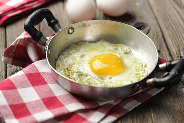 Míchaná vejce v železné pánvi na venkovském dřevěném stole - Fotografie, Obrázek