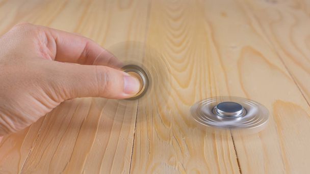 hand with spinner on table. - Photo, Image