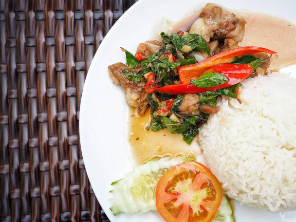 Тайская свинина с рисом и овощами на белой тарелке
 - Фото, изображение