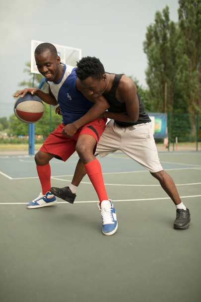 African american man friends playing on basketball court. Real authentic activity. - Фото, изображение