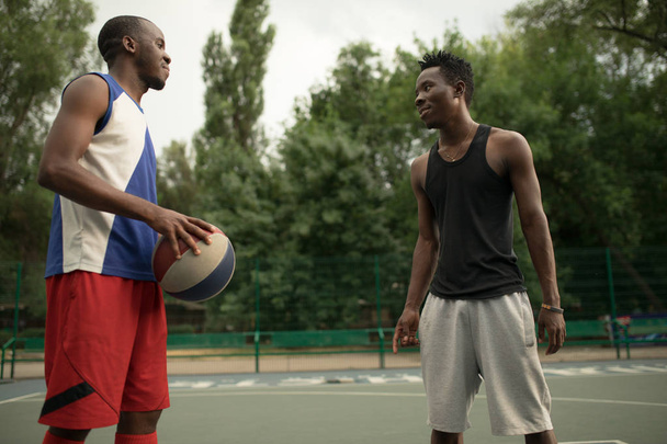 African american man friends playing on basketball court. Real authentic activity. - Foto, afbeelding