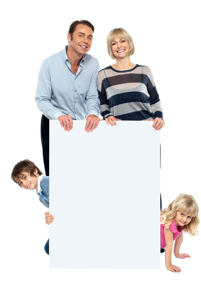 Lively family of four all around blank whiteboard - Fotografie, Obrázek