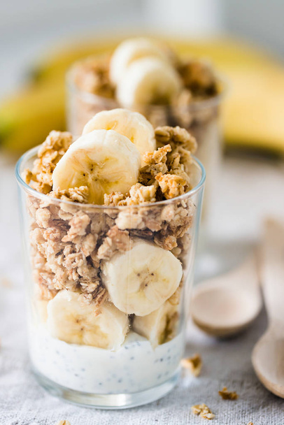Pudín de chía parfait, yogur en capas con plátano, granola. Desayuno saludable
 - Foto, Imagen