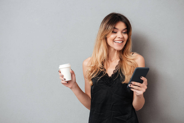 Portrait of a happy pretty girl holding coffee cup - 写真・画像