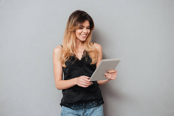 Portrait of a young smiling girl using tablet computer - Foto, immagini