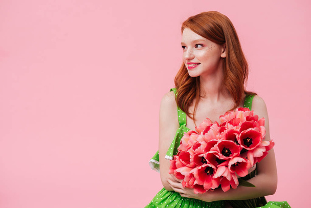 Pretty smiling woman holding bouquet of flowers - Fotografie, Obrázek