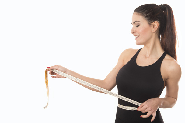 mujer joven que mide la cintura con cinta métrica - Foto, imagen
