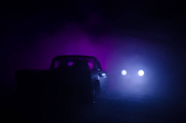 Radiowóz ściga samochód w nocy z mgłą w tle. 911 Awaryjny samochód policyjny jadący na miejsce zbrodni. - Zdjęcie, obraz