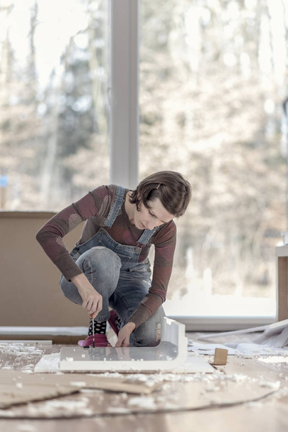 Image de style rétro d'une femme assemblant un mobilier bricolage à la maison
 - Photo, image