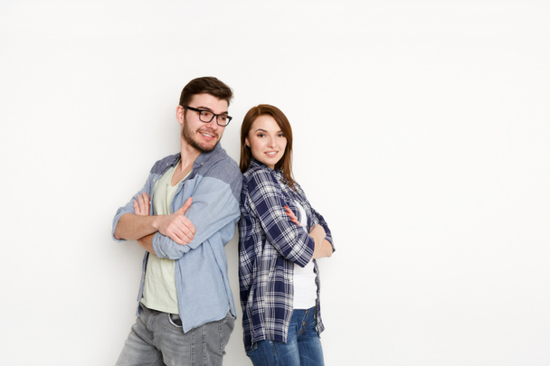 Happy couple at white background standing back to back - Photo, Image