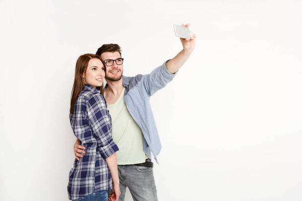 Happy casual couple doing selfie on smartphone, isolated - Photo, Image