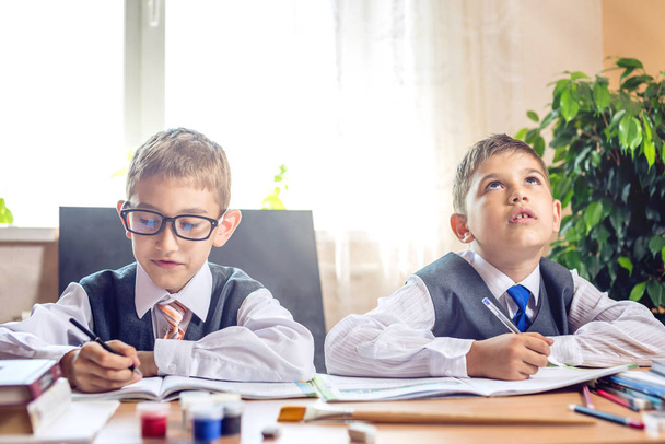 Powrót do szkoły. Słodkie dzieci siedząc przy biurku w klasie. Chłopców jest naukę. Szkoła Podstawowa koncepcja - Zdjęcie, obraz