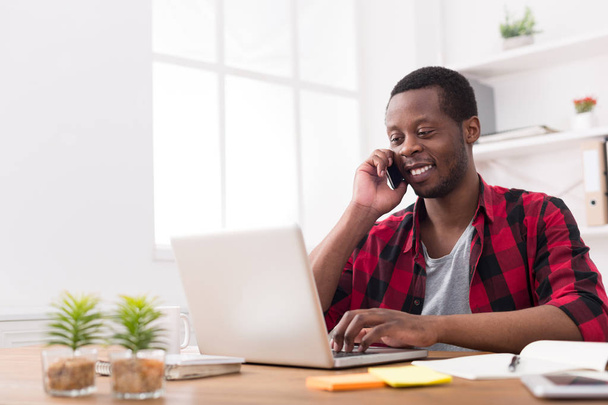 Jovem homem de negócios preto chamada telefone celular no escritório branco moderno
 - Foto, Imagem